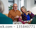 Group of senior people learning knitting together with caregiver tutor in a community center. 135840771