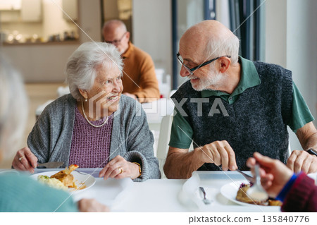 Elderly couple having lunch in community center cafeteria. 135840776