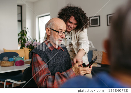 Tutor teaching seniors about phone scams and digital safety. Tutor teaching seniors about phone scams and digital safety. 135840788