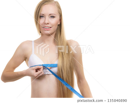 Woman measuring her chest breasts bust size 135840890
