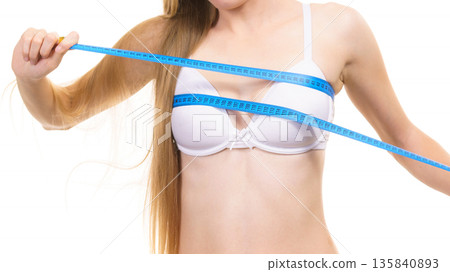 Girl measuring her chest breasts bust size Girl measuring her chest breasts bust size 135840893