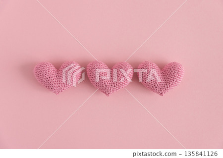 Crocheted Pink Hearts in a Row. Handmade Valentines Day Flatlay on Soft Pink Background 135841126