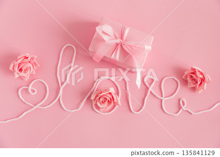 Gift Box and Roses with Love String. Romantic Valentines Day Flatlay on Pink Background Gift Box and Roses with Love String. Romantic Valentines Day Flatlay on Pink Background 135841129
