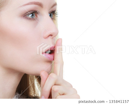 Woman making silence gesture with finger Woman making silence gesture with finger 135841157