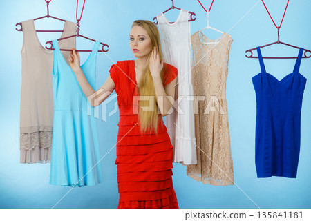 Woman choosing clothes in shop Woman choosing clothes in shop 135841181