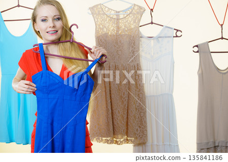 Woman choosing clothes in shop Woman choosing clothes in shop 135841186
