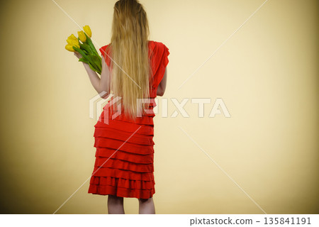 woman with yellow tulips bunch, back view woman with yellow tulips bunch, back view 135841191