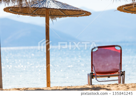 Sun parasols and deck chairs on beach Sun parasols and deck chairs on beach 135841245