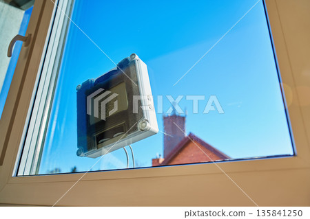 Window cleaning robot on glass surface Window cleaning robot on glass surface 135841250