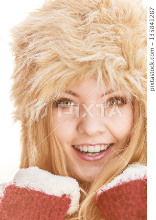 Portrait of pretty smiling woman in fur winter hat 135841287
