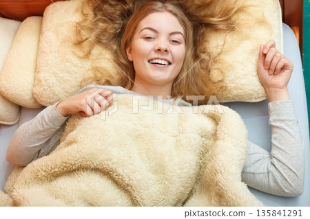 Woman waking up in bed in morning after sleeping Woman waking up in bed in morning after sleeping 135841291
