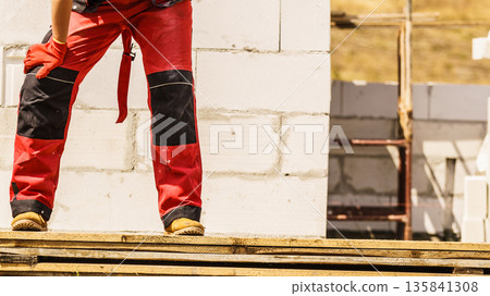 Person wearing red worker trousers 135841308