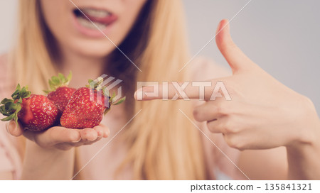 Girl showing fresh strawberries Girl showing fresh strawberries 135841321