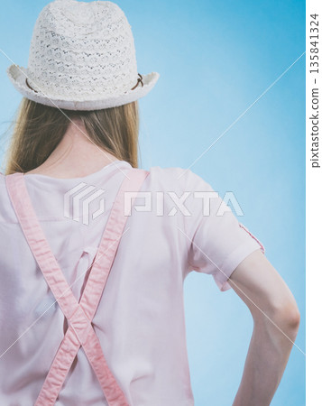 Woman in dungarees back view Woman in dungarees back view 135841324