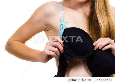Woman trying on black bra 135841355