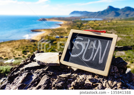 Black board with word sun against sea coast 135841388