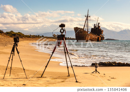 Camera on tripod and shipwreck Camera on tripod and shipwreck 135841406