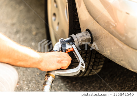 car at gas station being filled with fuel 135841540