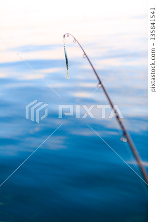 saltwater fishing - rod with wobbler and blue sea water 135841541