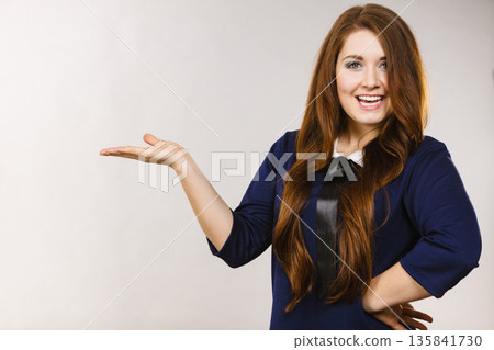 Happy elegant woman presenting copy space Happy elegant woman presenting copy space 135841730