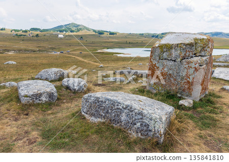Weathered ancient tombstones dot a windswept grassland Weathered ancient tombstones dot a windswept grassland 135841810