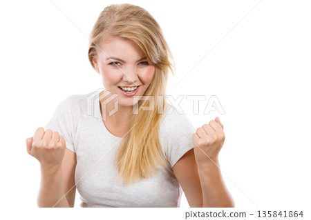 Happy positive blonde woman clenching fists Happy positive blonde woman clenching fists 135841864