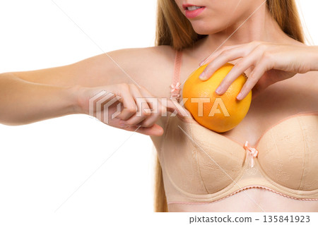 Woman small boobs puts big fruit in her bra Woman small boobs puts big fruit in her bra 135841923
