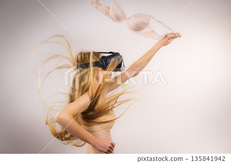Girl in virtual reality goggles holds bra Girl in virtual reality goggles holds bra 135841942