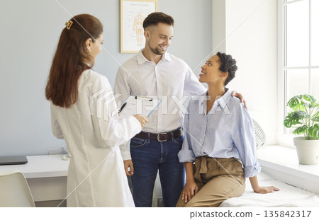 Couple and doctor meeting, talking on medical appointment, good news from physician in hospital Couple and doctor meeting, talking on medical appointment, good news from physician in hospital 135842317