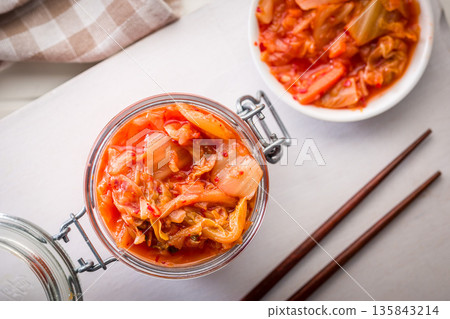 Fermented cabbage. Kimchi. Korean food in jar on white table. Top view. Fermented cabbage. Kimchi. Korean food in jar on white table. Top view. 135843214