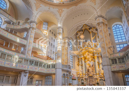 The Frauenkirche in Dresden shows its detailed interior with a dome, altar, and many decorations. Visitors can admire the architecture and art inside this historic church. The Frauenkirche in Dresden shows its detailed interior with a dome, altar, and many decorations. Visitors can admire the architecture and art inside this historic church. 135843337