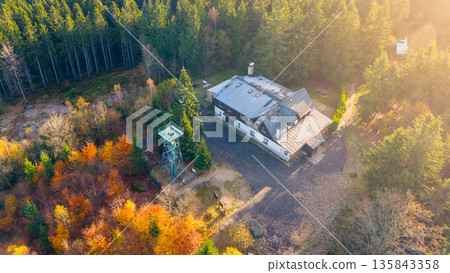 Slovanka Lookout Tower stands tall in the Jizera Mountains surrounded by vibrant autumn colors. This historical iron tower offers stunning views of the fall landscape in the Czech Republic. Slovanka Lookout Tower stands tall in the Jizera Mountains surrounded by vibrant autumn colors. This historical iron tower offers stunning views of the fall landscape in the Czech Republic. 135843358