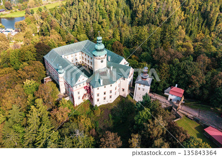 Aerial view of Lemberk castle surrounded by lush trees. The historic structure features towers and intricate architecture, offering a glimpse into its architectural significance and natural setting. Aerial view of Lemberk castle surrounded by lush trees. The historic structure features towers and intricate architecture, offering a glimpse into its architectural significance and natural setting. 135843364