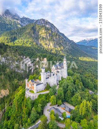 Neuschwanstein Castle stands majestically amidst the Bavarian mountains, surrounded by lush greenery and towering cliffs. A fairytale destination calling to dreamers. Neuschwanstein Castle stands majestically amidst the Bavarian mountains, surrounded by lush greenery and towering cliffs. A fairytale destination calling to dreamers. 135843399