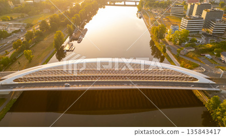 Troja Bridge crosses the Vltava River in Prague during sunrise. The scene shows the bridge with a clear view of the water and greenery along the banks. 135843417
