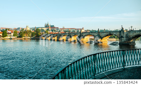 Prague Castle rises majestically over Charles Bridge, reflecting sunlight on the Vltava River. Prague Castle rises majestically over Charles Bridge, reflecting sunlight on the Vltava River. 135843424