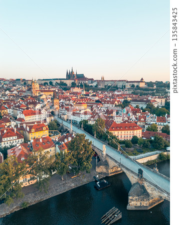 A breathtaking view of Prague at sunrise, showcasing the vibrant colors illuminating the city. The iconic Charles Bridge and the magnificent castle are silhouetted against the morning sky. A breathtaking view of Prague at sunrise, showcasing the vibrant colors illuminating the city. The iconic Charles Bridge and the magnificent castle are silhouetted against the morning sky. 135843425