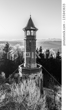 Stepanka lookout tower is located in the Jizera Mountains. It offers a view of the landscape. Winter surrounds the tower with frost on the trees during sunset. Stepanka lookout tower is located in the Jizera Mountains. It offers a view of the landscape. Winter surrounds the tower with frost on the trees during sunset. 135843633