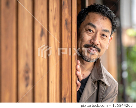 一個男人從陰影中對我們微笑 135844263