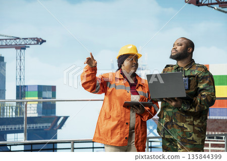 Soldier conducting maritime interdiction operations around drilling sites, speaking with offshore platform engineer. Military unit on drilling rig performs security patrols to prevent piracy Soldier conducting maritime interdiction operations around drilling sites, speaking with offshore platform engineer. Military unit on drilling rig performs security patrols to prevent piracy 135844399