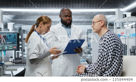 Medical researchers conducting patient evaluation in a laboratory drug study, collecting data on treatment outcomes and side effects, supporting toxicology and immunology research. Camera B. Medical researchers conducting patient evaluation in a laboratory drug study, collecting data on treatment outcomes and side effects, supporting toxicology and immunology research. Camera B. 135844404