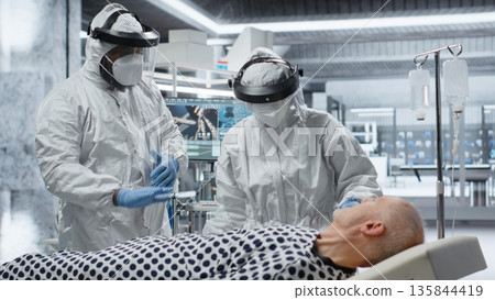 Doctors team in hazmat suits examining patient with infection symptoms in a secure laboratory, medical testing and diagnostics to prevent disease spread and support global healthcare. Camera B. Doctors team in hazmat suits examining patient with infection symptoms in a secure laboratory, medical testing and diagnostics to prevent disease spread and support global healthcare. Camera B. 135844419