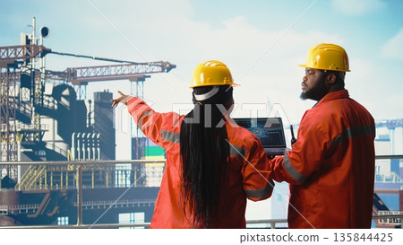 Offshore platform team using deep learning software on laptop to optimize drilling operations. Computer scientists on drilling rig ship analyzing geology data using AI technology, Offshore platform team using deep learning software on laptop to optimize drilling operations. Computer scientists on drilling rig ship analyzing geology data using AI technology, 135844425