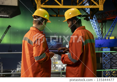 Engineering colleagues team uses AI deep learning on maritime oil rig under northern lights, 3D brain illustration software on laptop used for fuel management and extraction. Natural gas. 135844477