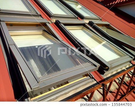 Red tiled house roof with attic windows. Roofing construction, window installation, modern architecture concept. 135844703