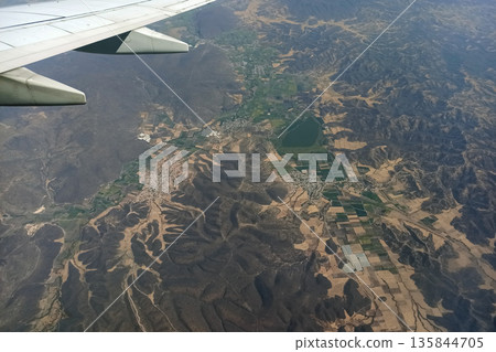 View through airplane window of commercial jet plane wing flying high in the sky. Air travelling concept 135844705