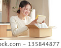 A Japanese woman looks happy after opening her package 135844877