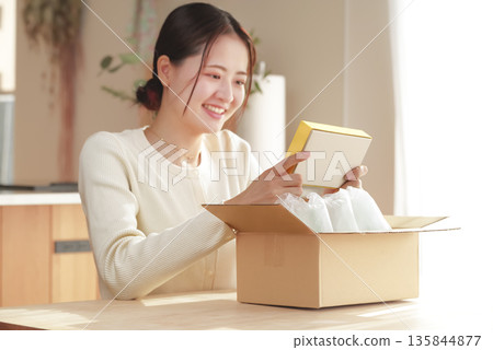 A Japanese woman looks happy after opening her package 135844877