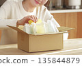 A Japanese woman looks happy after opening her package 135844879
