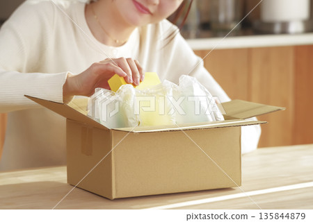 A Japanese woman looks happy after opening her package 135844879